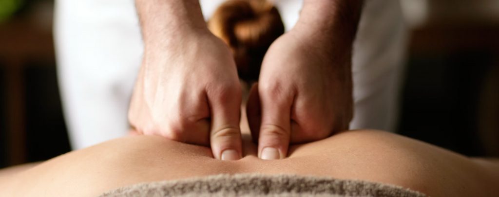 closeup of a mans hands massaging a woman's back